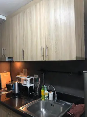 a kitchen with a sink and wooden cabinets at Casa Reyes in Manila