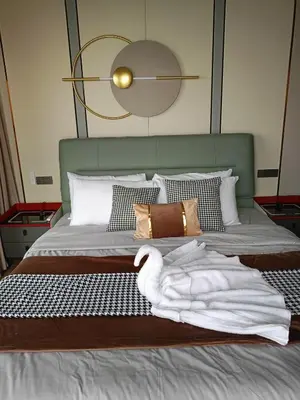 a bed with a green headboard with a towel on it at One Winstar Realty Corp in Manila