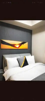 a bedroom with a white bed with a painting on the wall at One Winstar Realty Corp in Manila