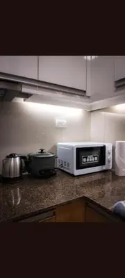 a kitchen counter with a toaster oven and a microwave at One Winstar Realty Corp in Manila