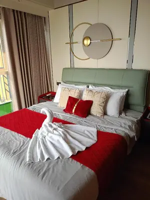 a bedroom with a large bed with red and white pillows at One Winstar Realty Corp in Manila
