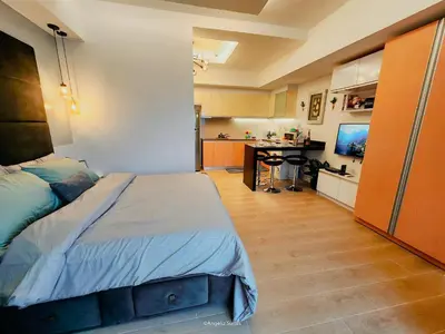 a bedroom with a large bed and a kitchen at One Bedroom Unit with Venice Canal View in Manila