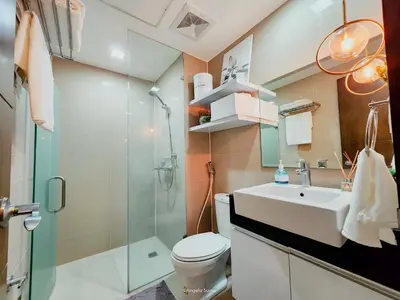 a bathroom with a toilet and a sink and a shower at One Bedroom Unit with Venice Canal View in Manila