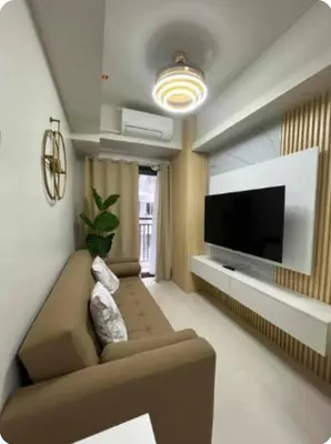 a living room with a couch and a flat screen tv at Elegant Suite Near Mall of Asia & Naia Airport in Manila