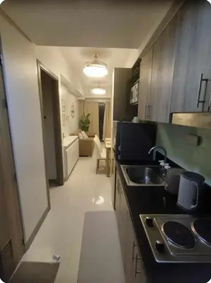 a kitchen with a sink and a living room at Elegant Suite Near Mall of Asia & Naia Airport in Manila