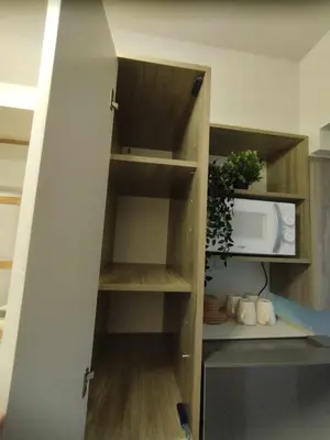 a kitchen with wooden shelves and a microwave at Elegant Suite Near Mall of Asia & Naia Airport in Manila