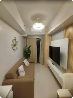 a living room with a couch and a flat screen tv at Elegant Suite Near Mall of Asia & Naia Airport in Manila