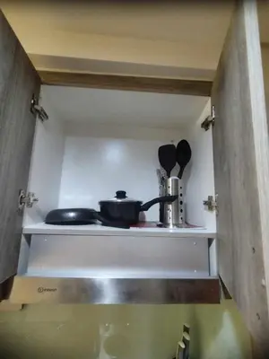 a kitchen shelf with a pot and utensils on it at Elegant Suite Near Mall of Asia & Naia Airport in Manila