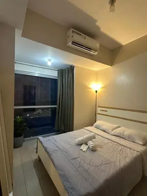 a bedroom with a bed with a air conditioner on it at Bayshore 2 Residential Resort Phase 1 in Manila