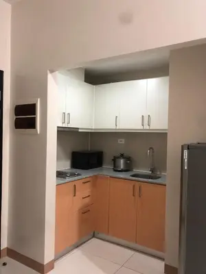 an empty kitchen with white cabinets and a sink at Bayshore 2 Residential Resort Phase 1 in Manila
