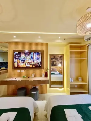 a hotel room with two beds and a tv on the wall at Crib2Go Lupita Suite with City Street View in Manila