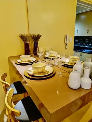 a dining table with glasses and plates on it at Crib2Go Lupita Suite with City Street View in Manila