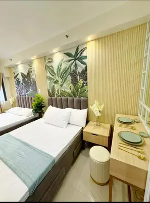 a hotel room with two beds and a table at Plete's Suite in Manila