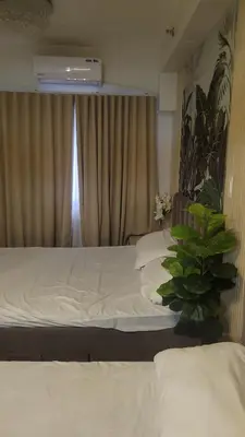 a bedroom with a white bed and a window at Plete's Suite in Manila