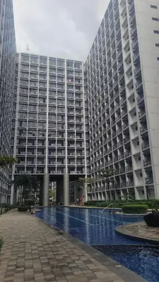 a large building with a pool in front of it at Plete's Suite in Manila