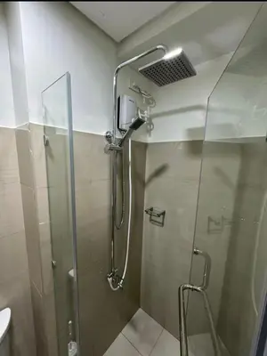 a shower with a glass door in a bathroom at Plete's Suite in Manila