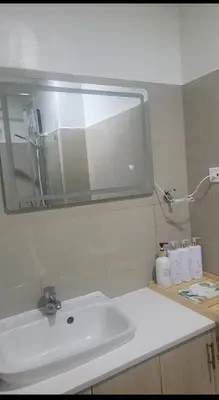 a bathroom with a white sink and a mirror at Plete's Suite in Manila