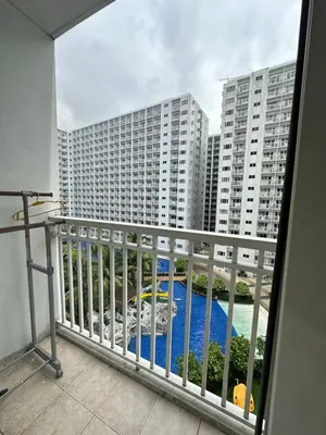 a balcony with a view of a pool and buildings at shore 880 staycation in Manila