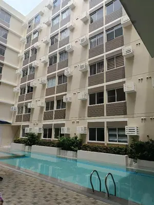 an apartment building with a swimming pool in front of it at Miranda's Suite by Fullerton in Silang