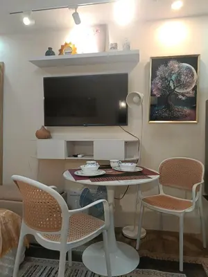 a living room with a table and chairs and a tv at Miranda's Suite by Fullerton in Silang