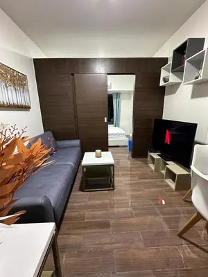 a living room with a couch and a tv at Queen size bed at Air Ayala Ave Makati in Manila