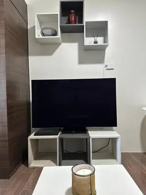 a living room with a large flat screen tv at Queen size bed at Air Ayala Ave Makati in Manila