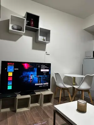 a living room with a large flat screen tv on a wall at Queen size bed at Air Ayala Ave Makati in Manila