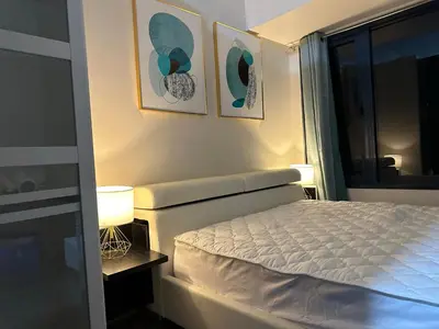 a bedroom with a bed and two pictures on the wall at Queen size bed at Air Ayala Ave Makati in Manila