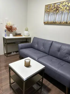 a living room with a blue couch and a table at Queen size bed at Air Ayala Ave Makati in Manila