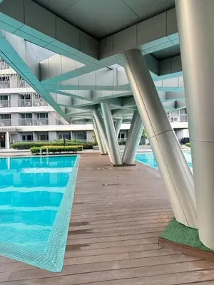 a building with a swimming pool in front of a building at El Romantico Staycation at Fame Residence in Manila