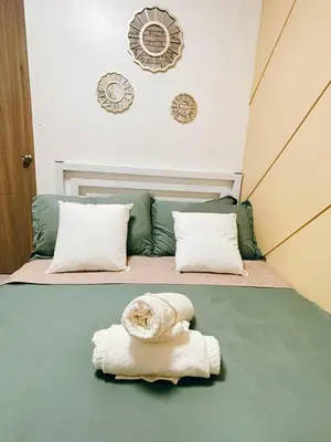 a bedroom with a bed with a towel on it at El Romantico Staycation at Fame Residence in Manila