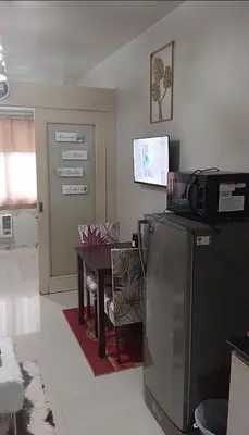 a living room with a refrigerator and a table at Joie Selene in Manila