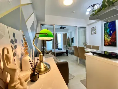 a living room with a table with a green lamp at Azure Urban Resort by Melrose Avenue in Manila