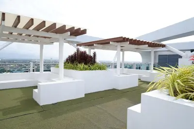 a view from the roof of a building with white benches at Azure Urban Resort by Melrose Avenue in Manila