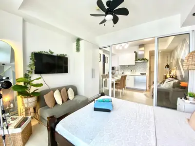 a living room with a large bed and a couch at Azure Urban Resort by Melrose Avenue in Manila