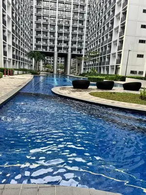 a large pool of blue water in front of a building at Shore Residences in Manila