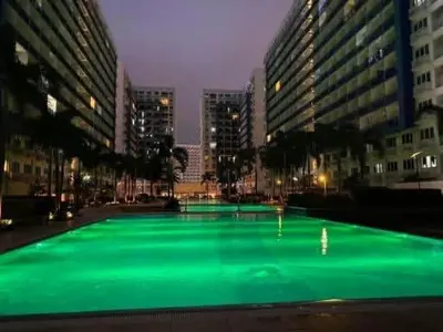 a green pool in the middle of a city at night at Searendipity - Sea Residences, Pasay City in Manila