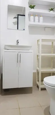 a bathroom with a white sink and a toilet at House of Bangtan at Grace Residences, Taguig in Manila