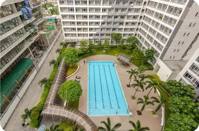 an overhead view of a swimming pool in a city at House of Bangtan at Grace Residences, Taguig in Manila