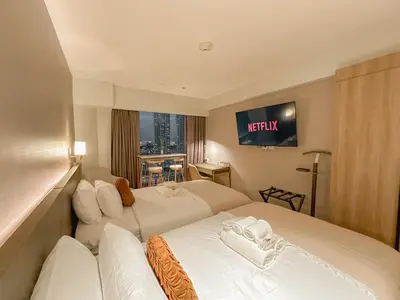 a hotel room with two beds and a television at Rockwell View Twin Suite with FREE WiFi Pool & Gym in Manila