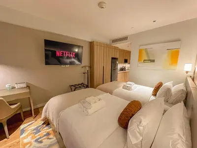 a hotel room with two beds and a sign on the wall at Rockwell View Twin Suite with FREE WiFi Pool & Gym in Manila