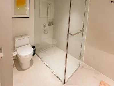 a bathroom with a toilet and a glass shower at Rockwell View Twin Suite with FREE WiFi Pool & Gym in Manila