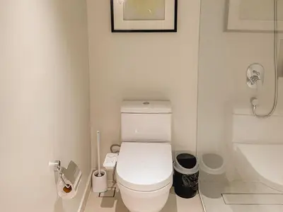 a white bathroom with a toilet and a sink at Rockwell View Twin Suite with FREE WiFi Pool & Gym in Manila