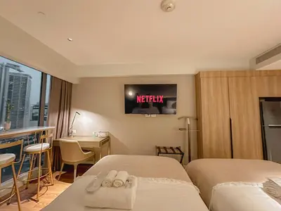 a hotel room with two beds and a tv on the wall at Rockwell View Twin Suite with FREE WiFi Pool & Gym in Manila