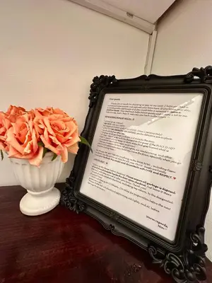 a table with a menu and a vase of orange roses at Studio Two Condominium - Alabang, BLK - Northgate Cyberzone, Filinvest City, Alabang - Netflix-ready Fiber Wi-Fi in Manila