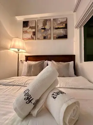 a white bed with towels and pillows on it at Studio Two Condominium - Alabang, BLK - Northgate Cyberzone, Filinvest City, Alabang - Netflix-ready Fiber Wi-Fi in Manila