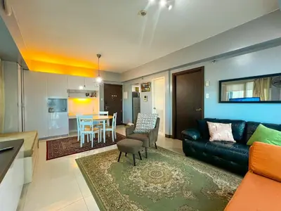 a living room with a couch and a dining room at Le Grand one in Manila