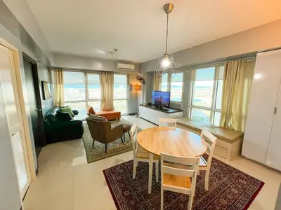 a living room with a dining table and a living room at Le Grand one in Manila