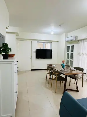 a kitchen and dining room with a table and a tv at Vincondotel Near BGC Fairlane in Manila