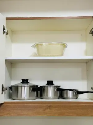 two pots and a bowl on a shelf in a kitchen at Vincondotel Near BGC Fairlane in Manila